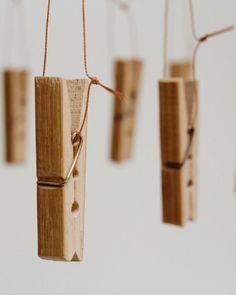 several pieces of wood are hanging from strings