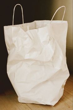 a white paper bag sitting on top of a wooden floor