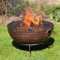 a fire pit sitting on top of a lush green field