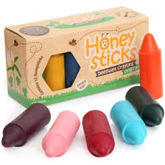 four crayons in front of a box of honey sticks