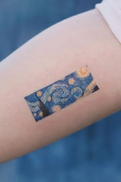 a person with a tattoo on their arm that has the starry night painting on it