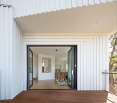 an open living room and dining area with sliding glass doors on the side of the house