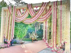 an outdoor wedding ceremony with flowers and greenery on the side walk, decorated in pink and yellow colors