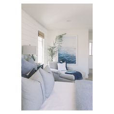 a white room with blue and gray decor on the walls, couches and pillows