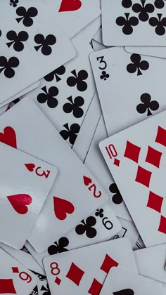 many playing cards are laying on top of each other