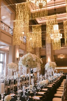 the tables are set with black linens, white flowers and tall centerpieces