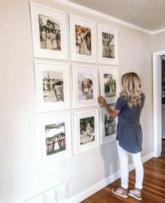 a woman standing in front of a wall with pictures on it