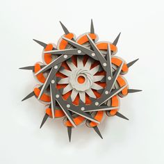 an orange and white object with metal spikes on it's center piece, in the shape of a starburst