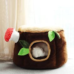 a cat bed with a mushroom hat on it's head and a stuffed animal inside