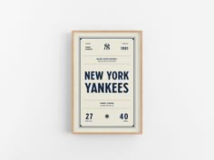 the new york yankees poster is displayed on a white wall in front of a wooden frame