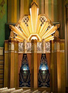 an ornately decorated building with columns and lights on the front wall, in a church