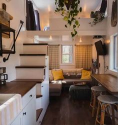 the interior of a tiny home with stairs leading up to the living room and kitchen