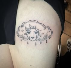 a woman's face with rain coming out of her cloud tattoo on the thigh