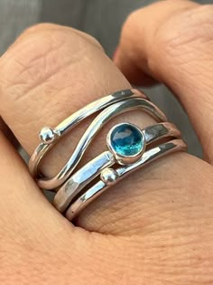 This silver stack ring is made up of four Sterling Silver rings which  sit together. There are two silver 'bubble' rings, a wave ring and a fourth ring featuring a 5mm London Blue Topaz.  Please let me know the size you require at Checkout. Also if possible please let me know whether you used a narrow ring sizer (approx: 4mm wide) or a wide ring sizer (approx: 6mm wide). This ensures a perfect fit. Blue Sterling Silver Fusion Rings, Fusion Style Blue Sterling Silver Rings, Unique Blue Stackable Jewelry, Unique Blue Adjustable Stackable Rings, Silver Stackable Rings With Blue Topaz For Gift, Silver Stackable Blue Topaz Rings For Gift, Unique Stackable Blue Rings, Unique Blue Stackable Round Rings, Unique Blue Stackable Rings