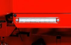 the front end of a red truck with its lights on