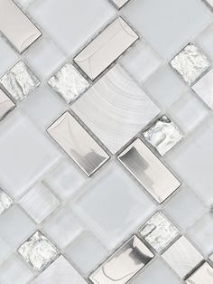 a white tiled wall with silver squares and rectangles in the middle, all on top of each other