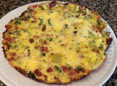 a pizza sitting on top of a white plate covered in cheese and veggies