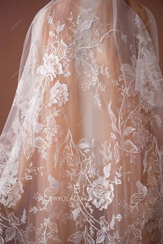 the back of a wedding veil with white flowers on it