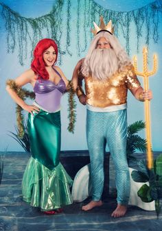 two people dressed as ariel and the little mermaid are standing next to each other in front of a backdrop