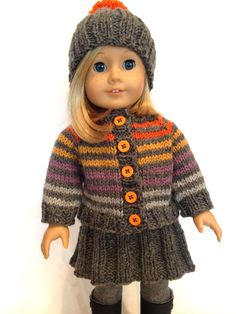 a doll is wearing a knitted coat and hat with buttons on the collarline