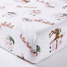 a white sheet with santa claus and reindeers on it's side, in front of a white background