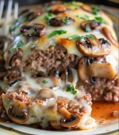 a close up of a plate of food with meat and mushrooms on it, covered in gravy