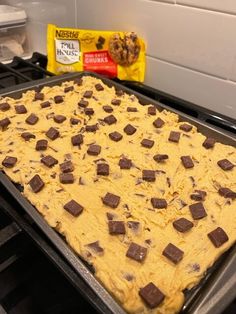 a baking pan filled with batter and chocolate chips on top of an oven burner