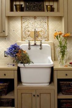 a white sink sitting in the middle of a kitchen next to wooden cabinets and drawers