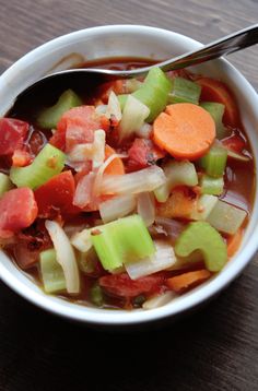 a bowl of soup with carrots, celery and other vegetables in it