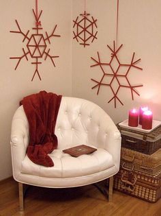 a white chair sitting in front of two snowflakes hanging from the wall