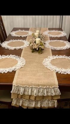 the table is set with a candle and some flowers on it, along with two placemats