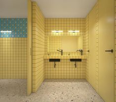 an empty public restroom with yellow walls and tile flooring, two sinks and mirrors