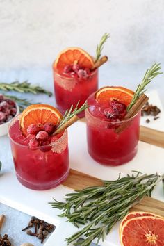 two glasses filled with blood orange and rosemary garnish