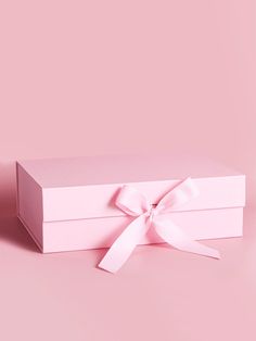 a pink box with a bow on the front and side, against a pink background