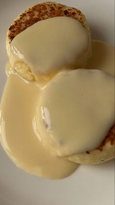 two biscuits covered in gravy on a white plate