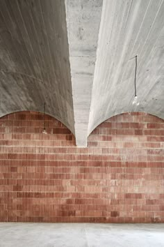 an empty room with brick walls and flooring in the corner, as seen from below