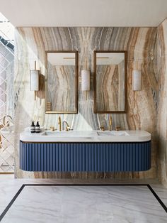 a bathroom with two sinks and mirrors on the wall next to each other in front of a large mirror