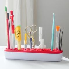 there are many pens and scissors in the holder