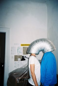 two people standing next to each other in a room with duct tape on their heads