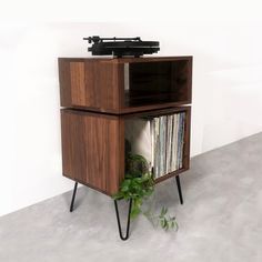 a record player is sitting on top of a shelf with records and plants in it