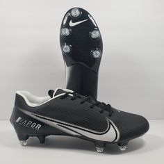 a pair of black and white soccer cleats with lights on them, sitting in front of a gray background