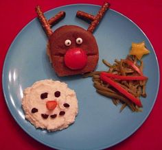 a blue plate topped with food covered in frosting and reindeer nose decorations on top of it