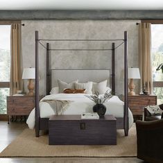 a bedroom with a canopy bed and two lamps on the side tables in front of it