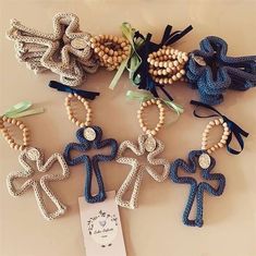 several small crocheted crosses are arranged on a table with a tag attached to them