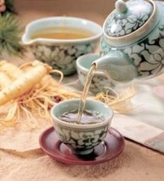 tea being poured into a cup on top of a saucer next to sliced bananas