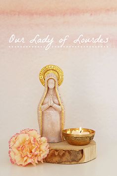 an image of a statue and bowl on a table with flowers in front of it