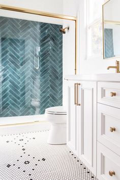 a bathroom with white and blue tiles on the walls, flooring and shower stall