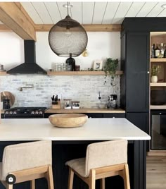 the kitchen is clean and ready to be used for cooking or baking, with two stools in front of the island