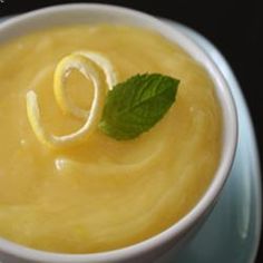 a close up of a bowl of soup with a leaf on the top and an o in the middle