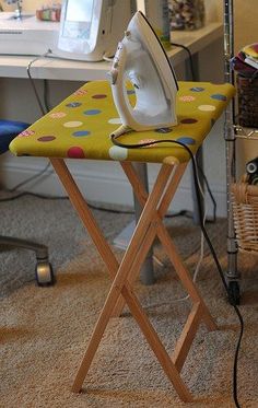 an ironing board sitting on top of a wooden chair in front of a computer desk